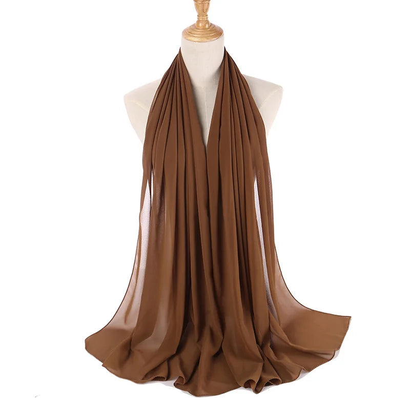 Ein brauer Chiffon-Hijab ist um den Hals und die Schultern einer Mannequin drapiert.