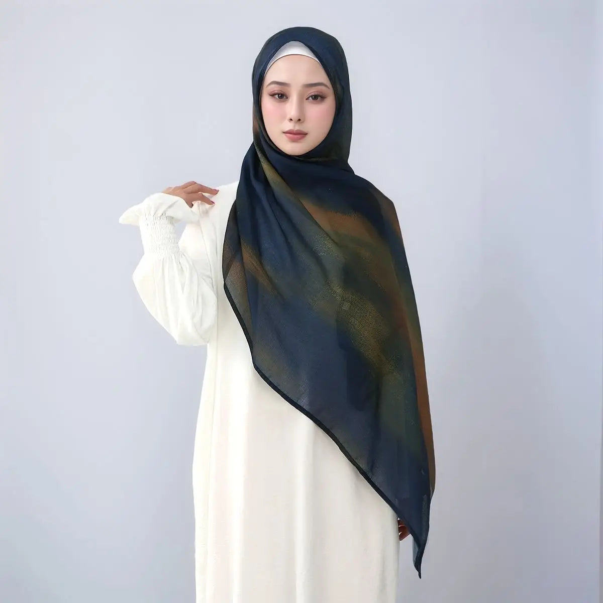 Eine Frau trägt einen dunkelblauen Aquarell-Leinen-Baumwollscharf und ein weißes Kleid.