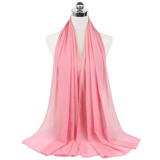 A pink chiffon hijab scarf draped around a mannequin's neck.