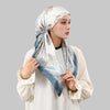 A woman wearing an elegant satin silk instant hijab scarf in blue and silver tones.