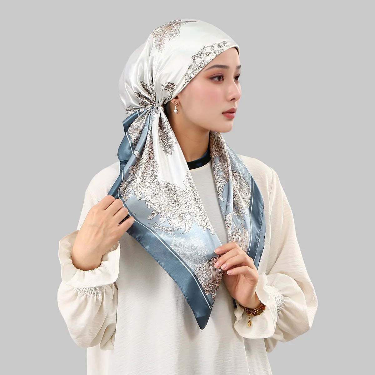 A woman wearing an elegant satin silk instant hijab scarf in blue and silver tones.