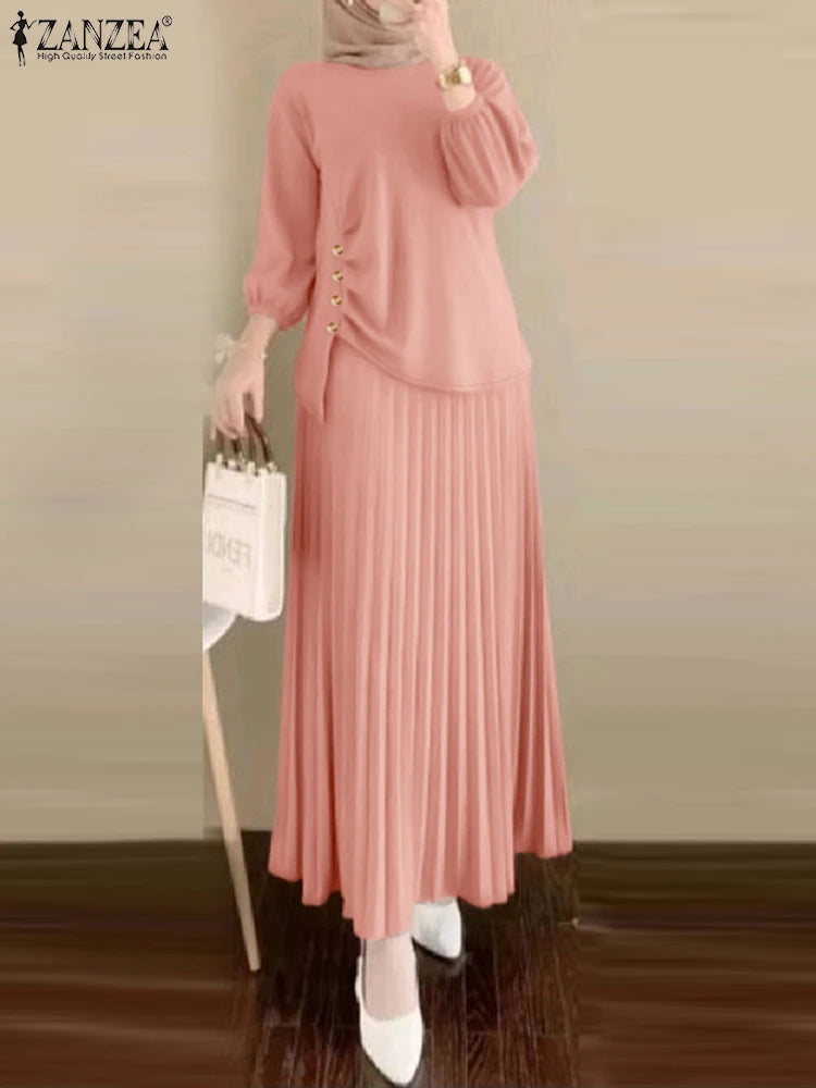 Une femme portant une robe et un haut plissés roses avec des boutons dorés, stylisés comme un élégant ensemble musulman.