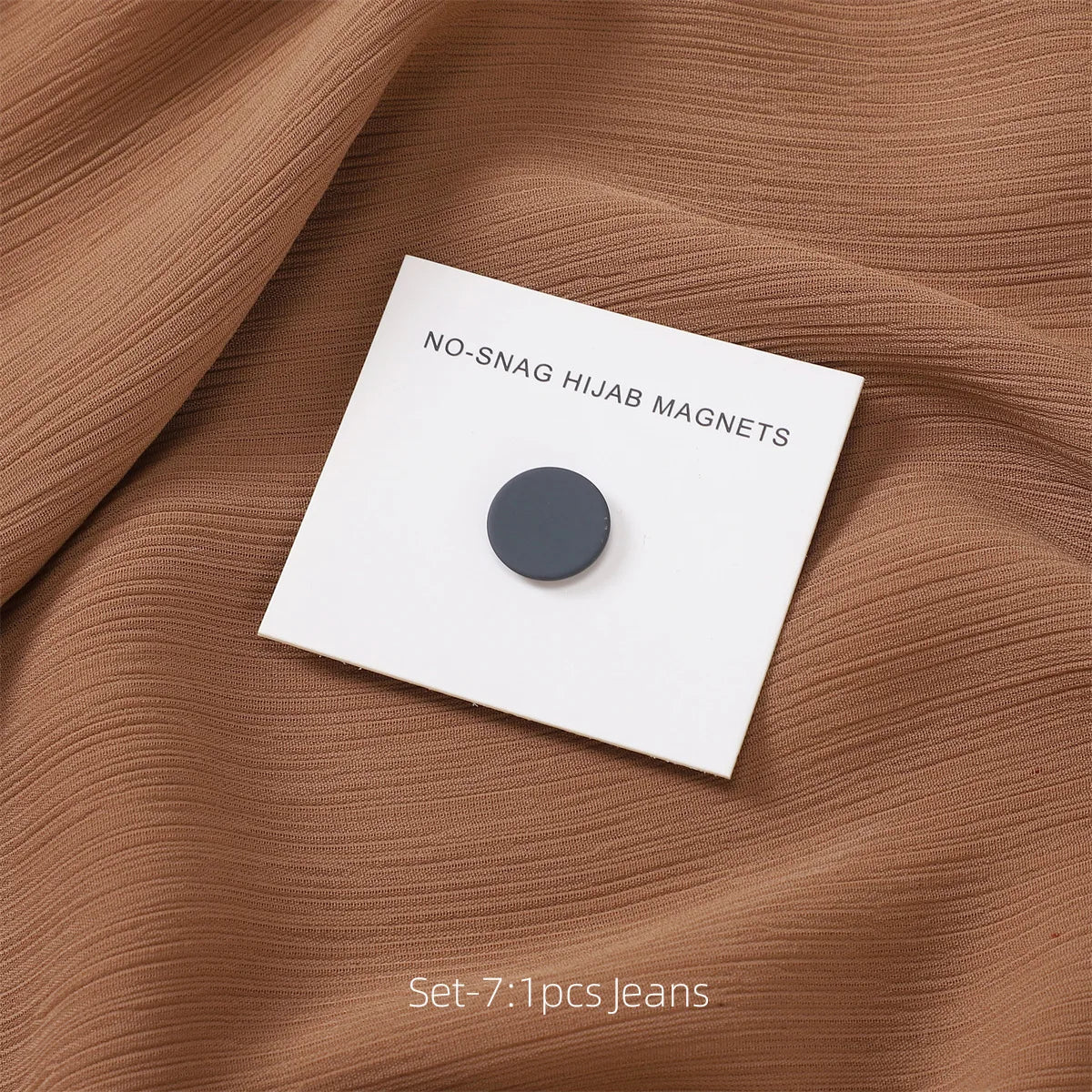 Alfiler de hijab magnético blanco sobre tela marrón texturizada, con texto NO-SNAG HIJAB MAGNETS.