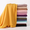 A stack of premium modal jersey hijabs in various shades of yellow, pink, purple, green, and black.