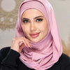 Eine Frau trägt einen rosa, sofort einsatzbereiten Jersey-Hijabschal und blickt direkt in die Kamera.