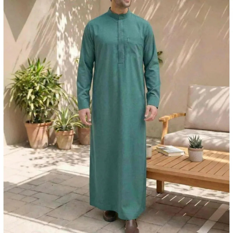 Un hombre vistiendo una túnica casual bordada en color verde azulado de jubba.