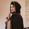 Una mujer vistiendo un elegante hiyab de gasa marrón oscuro adornado con pedrería dorada.