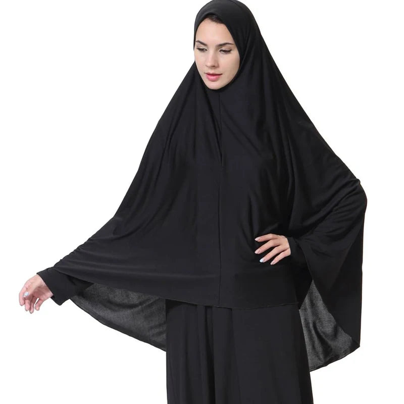 Una mujer vistiendo un elegante pañuelo hijab negro ligero y ropa modesta.
