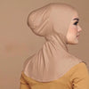Une femme portant un hijab et un foulard beige avec un haut jaune moutarde.