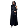 Eine Frau trägt ein elegantes schwarzes Polka-Dot-Abaya-Cardigankleid mit langen Ärmeln und einem langen Rock.