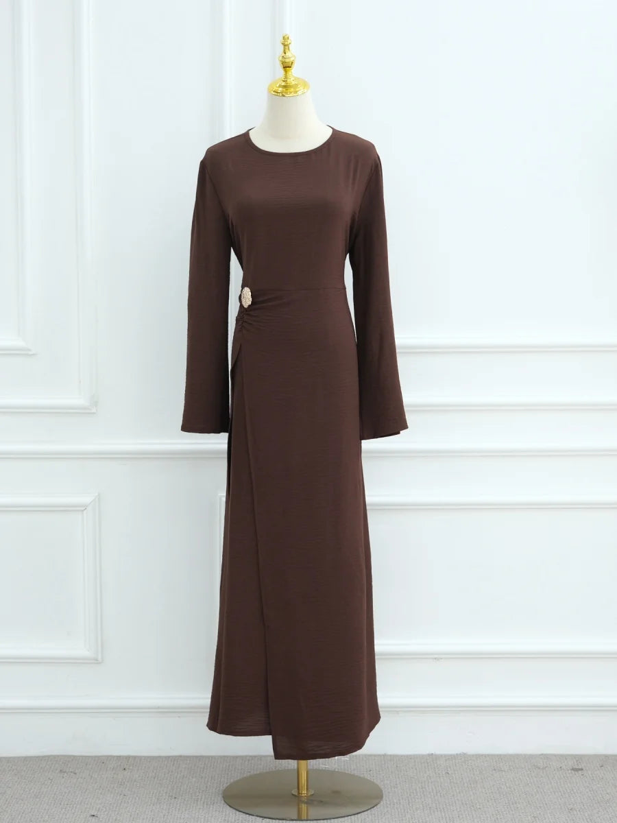 Une abaya élégante à manches longues, brune et de couleur unie, avec cordon de serrage, présentée sur un mannequin.