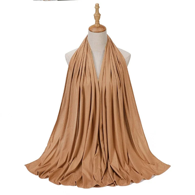 Pañuelo de jersey de algodón en hilo beige drapeado alrededor del cuello de un maniquí.