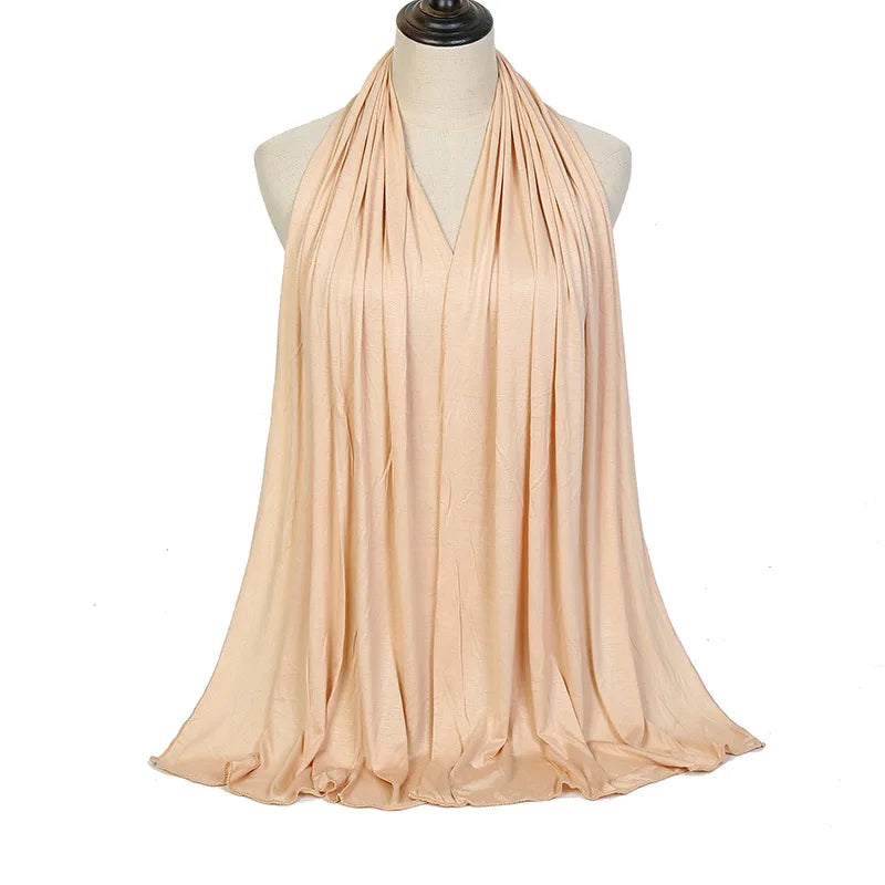 Bufanda hijab de algodón modal premium beige drapeada alrededor del cuello de un maniquí.