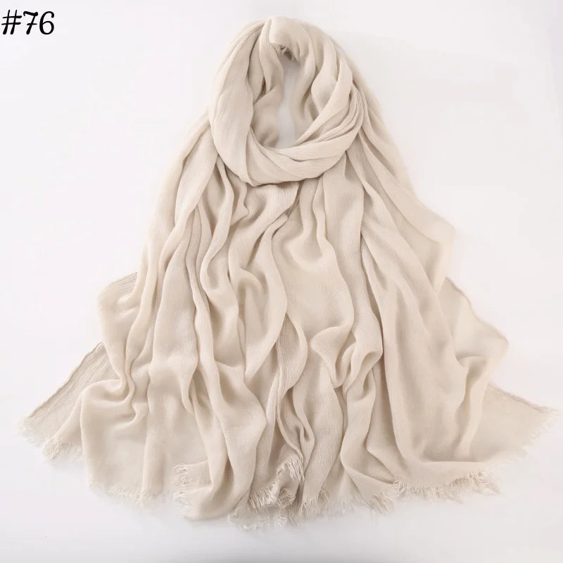 Foulard hijab en coton viscose beige drapé et plié sur fond blanc.