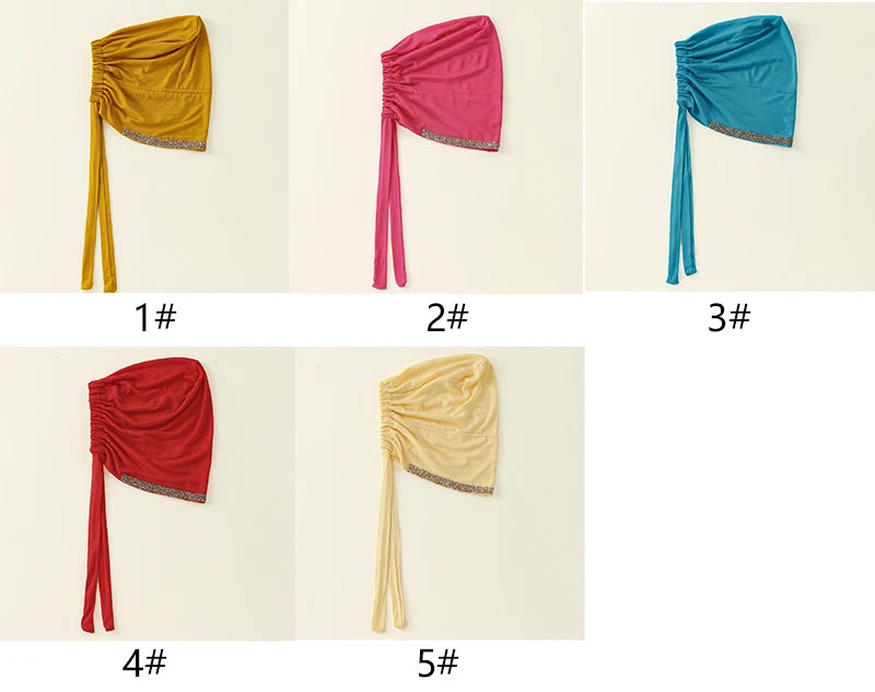 Fünf bunte elegante Strass-Hijab-Caps vertikal vor weißem Hintergrund.