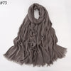 Foulard hijab en coton viscose gris doux drapé sur fond blanc.