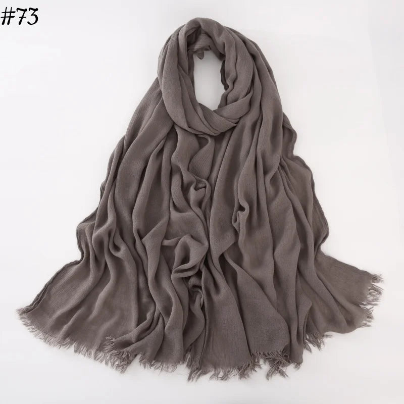 Foulard hijab en coton viscose gris doux drapé sur fond blanc.
