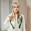 Eine Frau präsentiert einen floral gemusterten Voile-Hijab, drapiert um ihren Hals und ihre Schultern.