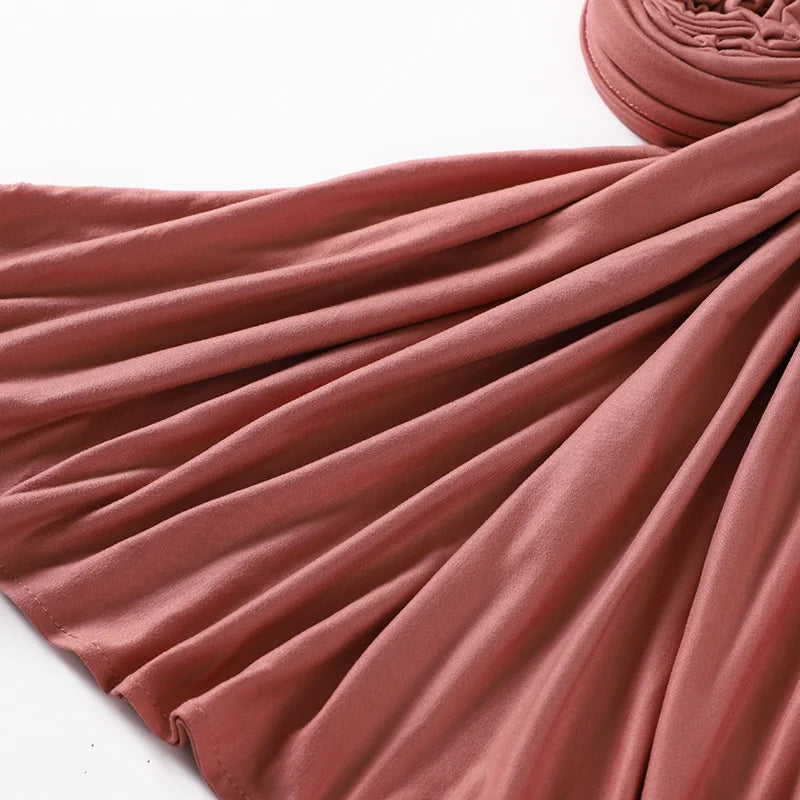 Primer plano de un elegante pañuelo de hijab de algodón premium elástico color rosa polvoriento.