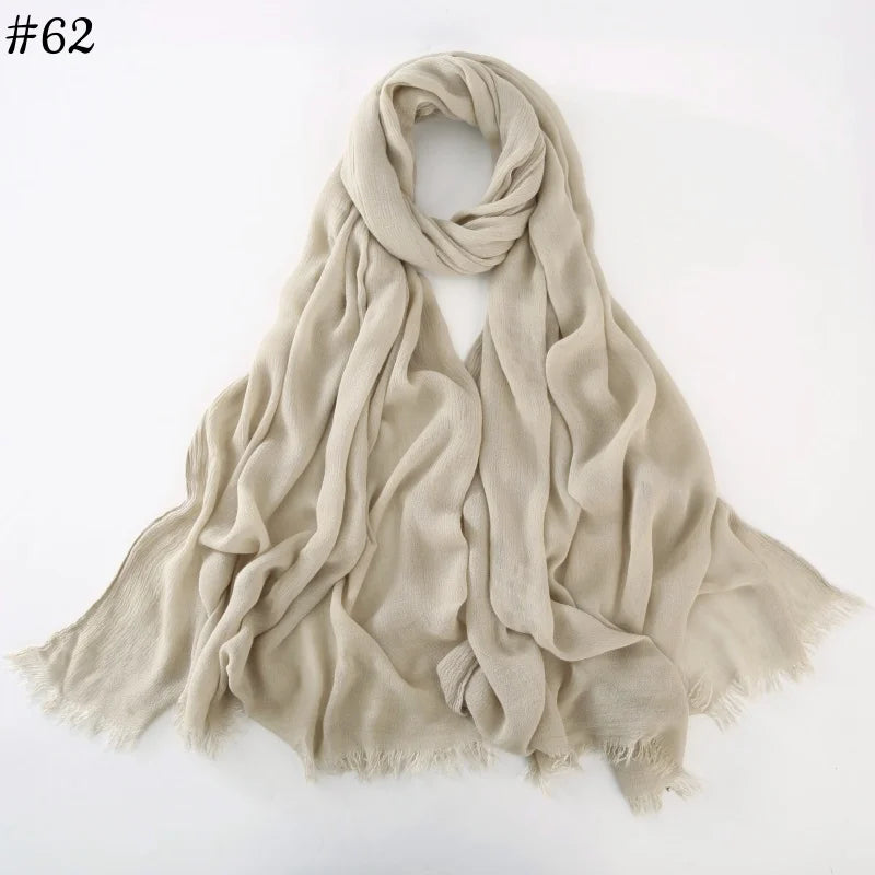 Foulard hijab en coton viscose beige clair, drapé et plié sur fond blanc.