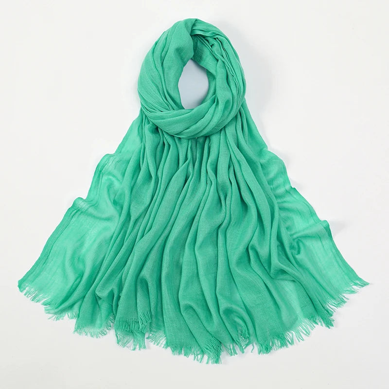 Pañuelo de hijab modal de bambú verde menta fluido, drapeado alrededor del cuello.