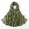 Un gran pañuelo de hijab de modal de rayón color verde oliva sólido, drapeado alrededor del cuello.