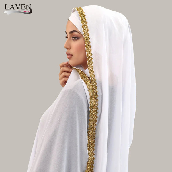 A woman wearing an elegant white chiffon hijab adorned with gold rhinestone detailing.