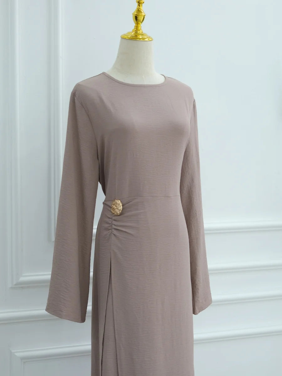 Une robe abaya de couleur mauve uni à manches longues, présentée sur un mannequin.