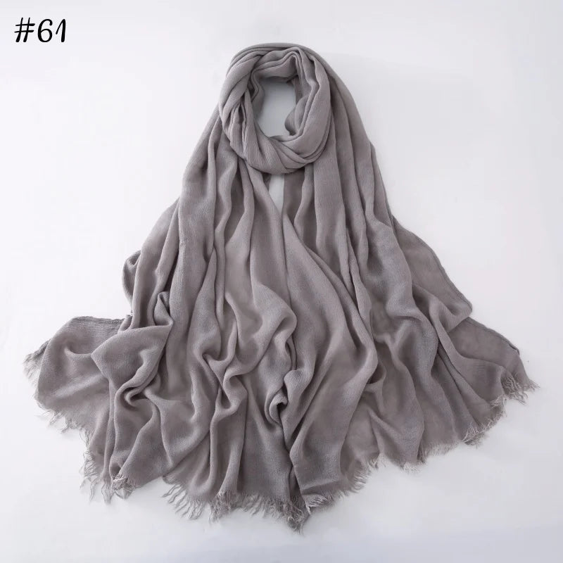 Écharpe hijab en coton viscose gris doux, drapée et pliée sur fond blanc.