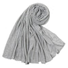 Un foulard hijab en jersey de coton gris, roulé et drapé, montrant sa texture douce.