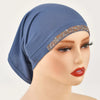 Modelo usando un elegante hiyab de algodón elástico y transparente azul marino con ribetes dorados brillantes.