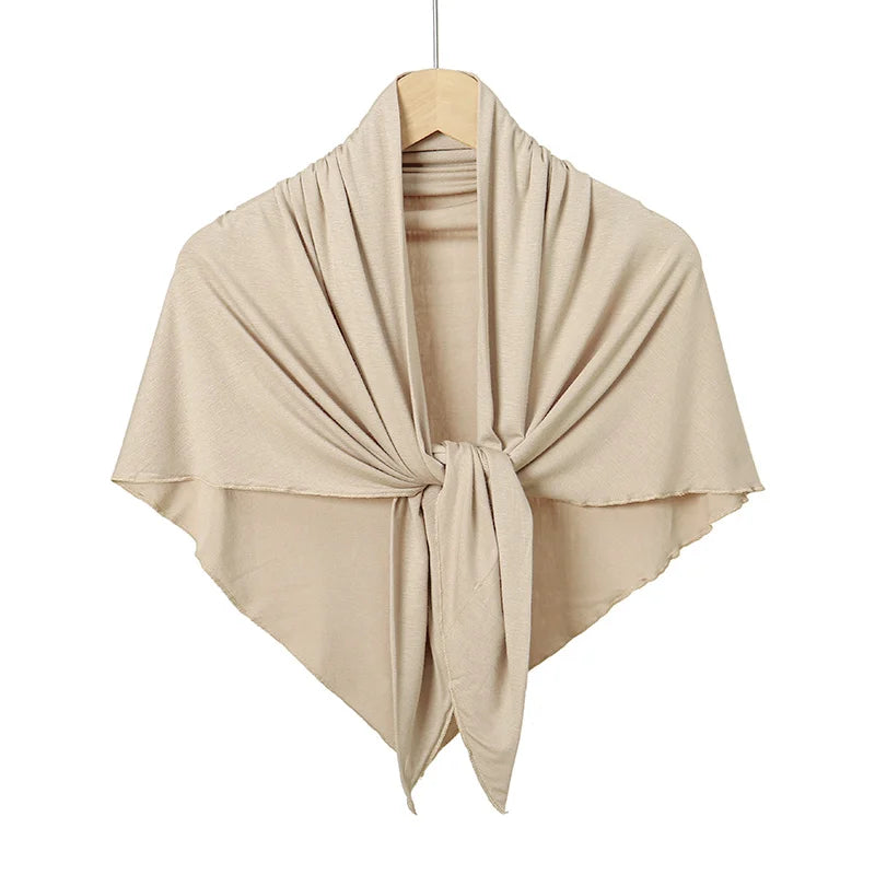 Un foulard hijab en maillot de triangle beige plié et exposé sur un cintre.