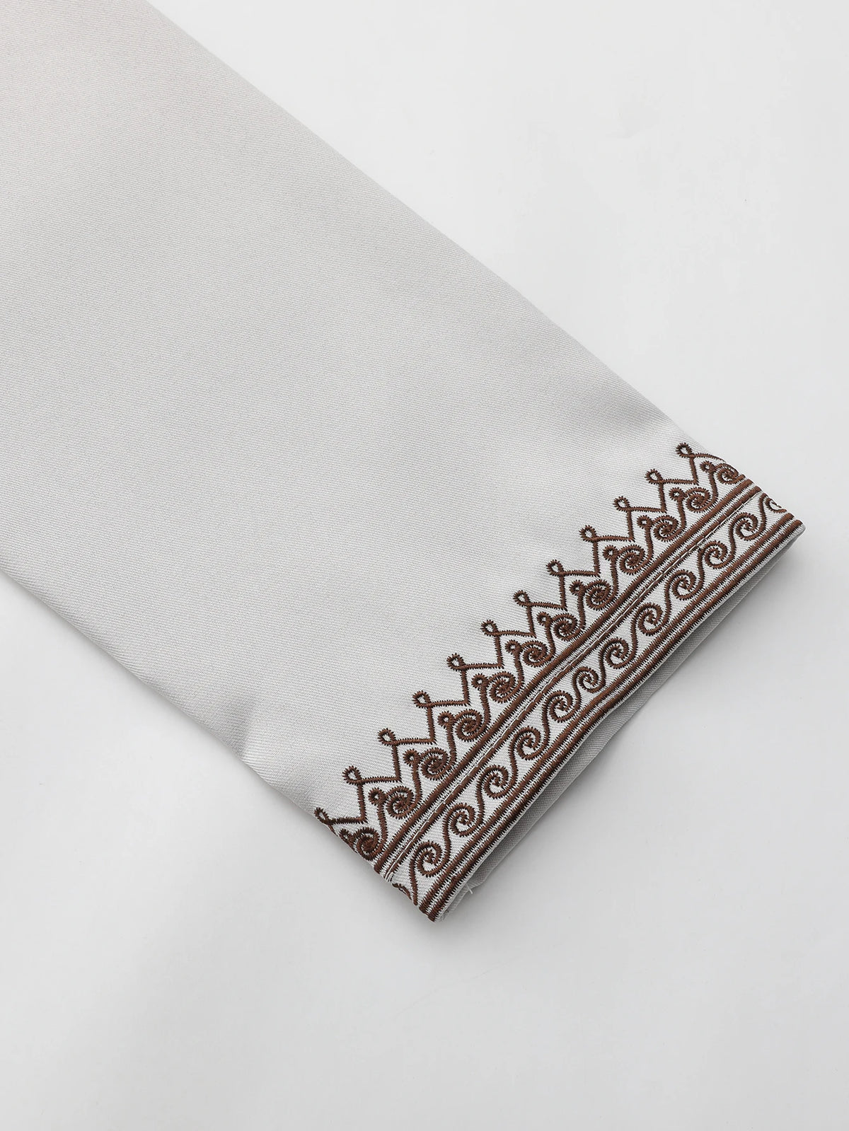 Close-up of a light gray Moroccan men's ethnic thobe with an embroidered stand collar detail.