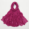 Étoffe crinkle magenta vibrante, foulard/châle drapé autour du cou et flottant.