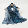 Fließender blauer Aquarell-Hijab-Schal auf einem Holzbügel.