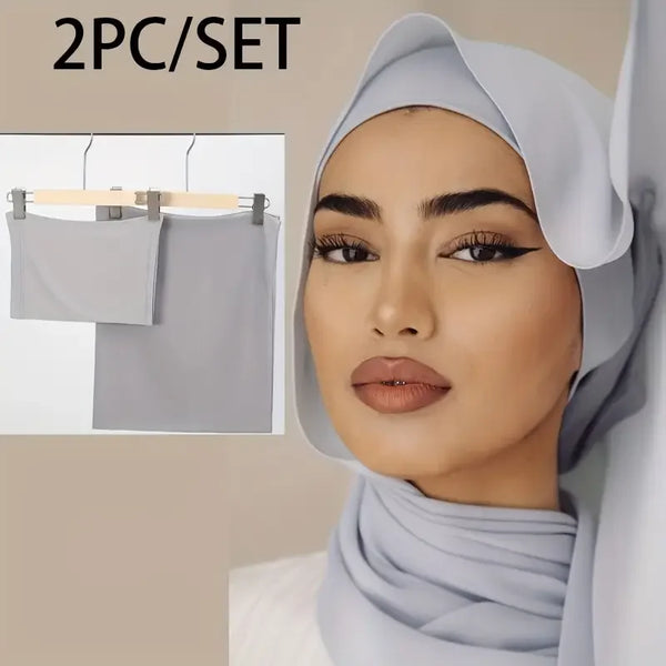 A woman wearing a light gray two-piece chiffon hijab set, featuring a headscarf and matching fabric.