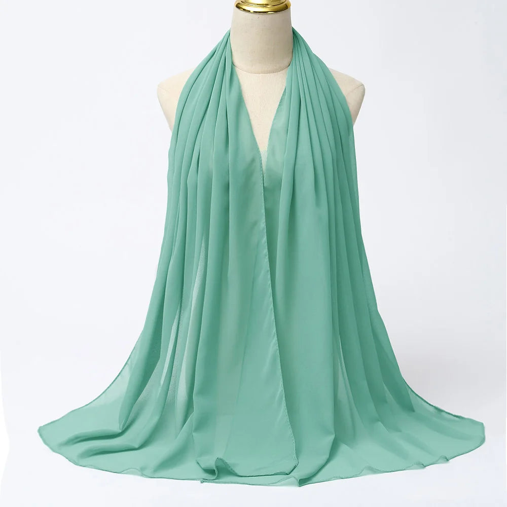 Fließender minigrüner Chiffon-Hijabschal um den Hals einer Mannequin.