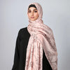 Eine Frau trägt einen rosa Boho-Aquarell-Hijabschal mit schwarzer Kleidung.