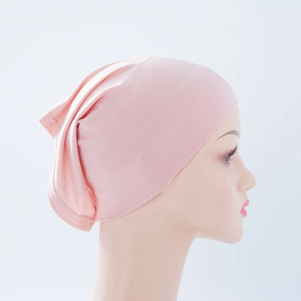 Helle rosa Bambus-Jersey-Turban-Kappe auf einem Mannequin-Kopf.