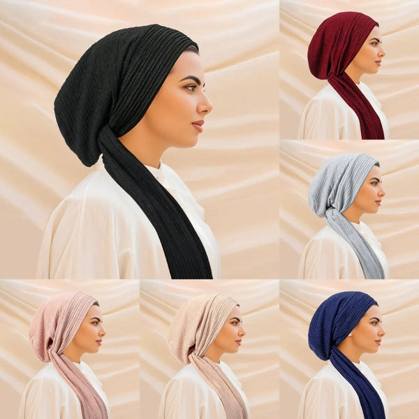 A set of solid color turban hijabs in black, maroon, and gray worn by a woman.