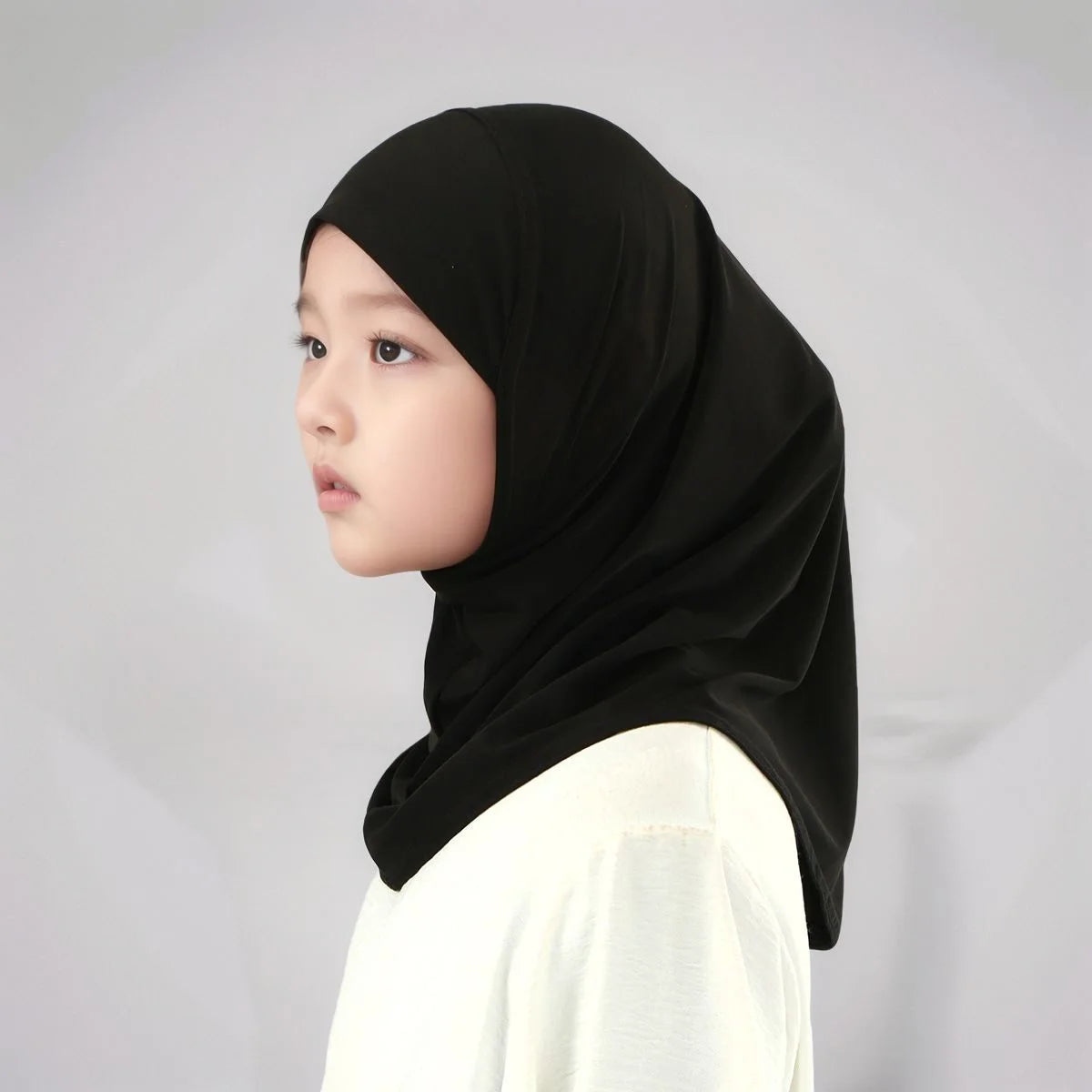 Junge trägt einen schwarzen sofort trocknenden Baumwoll-Modal-Hijab und ein weißes Oberteil.