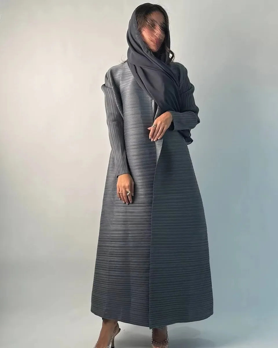 Una mujer vistiendo un cárdigan abaya plisado gris y un pañuelo a juego.