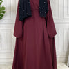 Maroon maxi abaya für Frauen mit schwarzem Zier und langen Ärmeln.