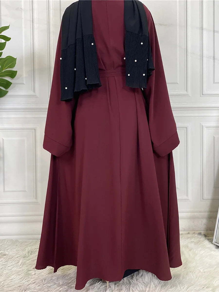Maroon maxi abaya für Frauen mit schwarzem Zier und langen Ärmeln.