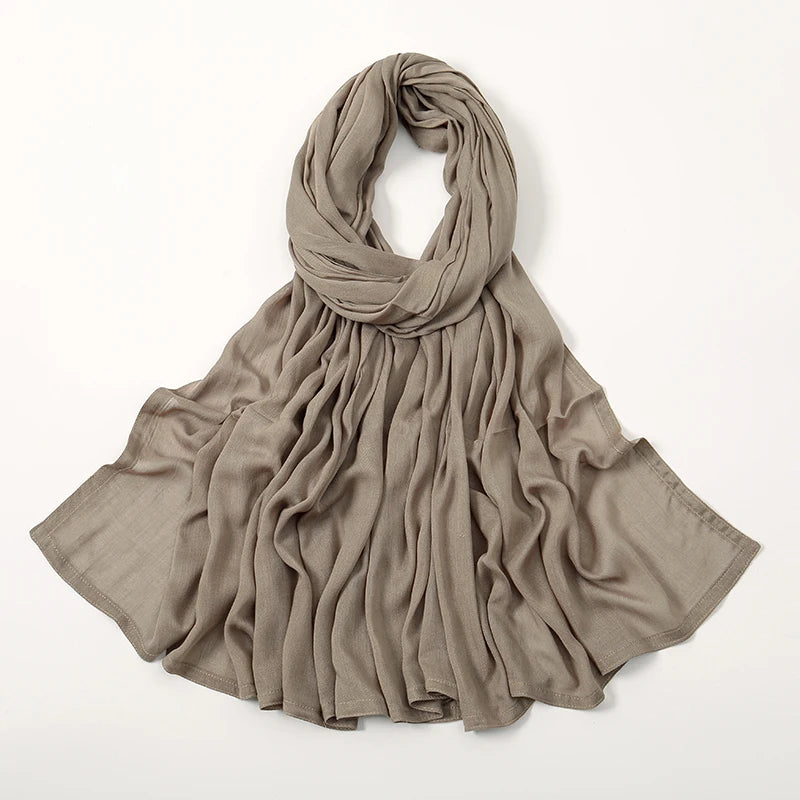 Ein drapierter, einfacher beige Viskose-Hijab für Frauen, flach gelegt.