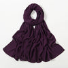 Ein drapiertes, tiefviolettes Chiffon-Hijab-Schal, gefaltet und vor weißem Hintergrund präsentiert.