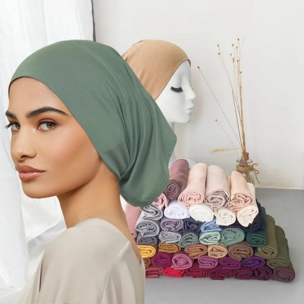 A model wearing a sage green bamboo jersey tube hijab cap next to various rolled fabric colors.