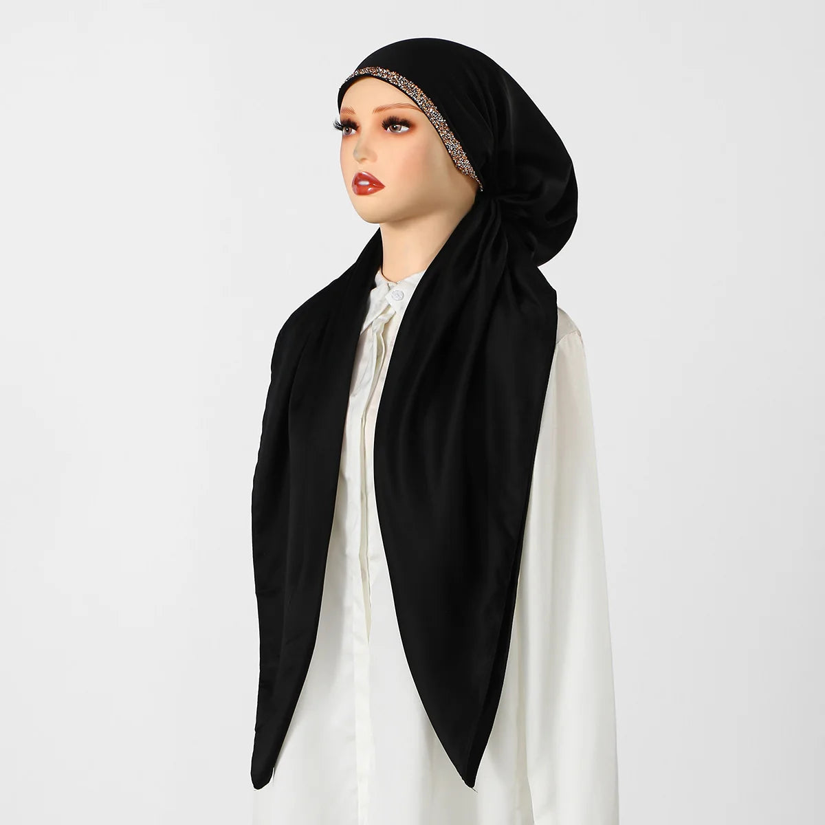 A woman models an elegant black satin silk instant hijab scarf with a gold embroidered border.