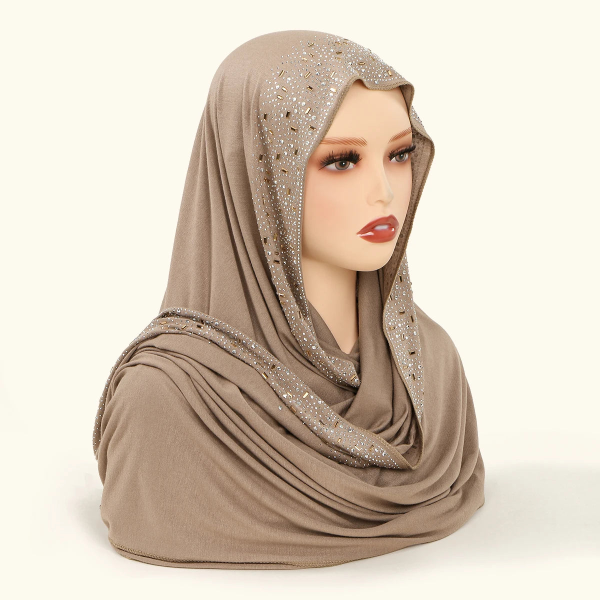 Ein Model trägt einen beigen Luxus-Strangenhals-Hijabschal, der um ihren Kopf und Hals drapiert ist.