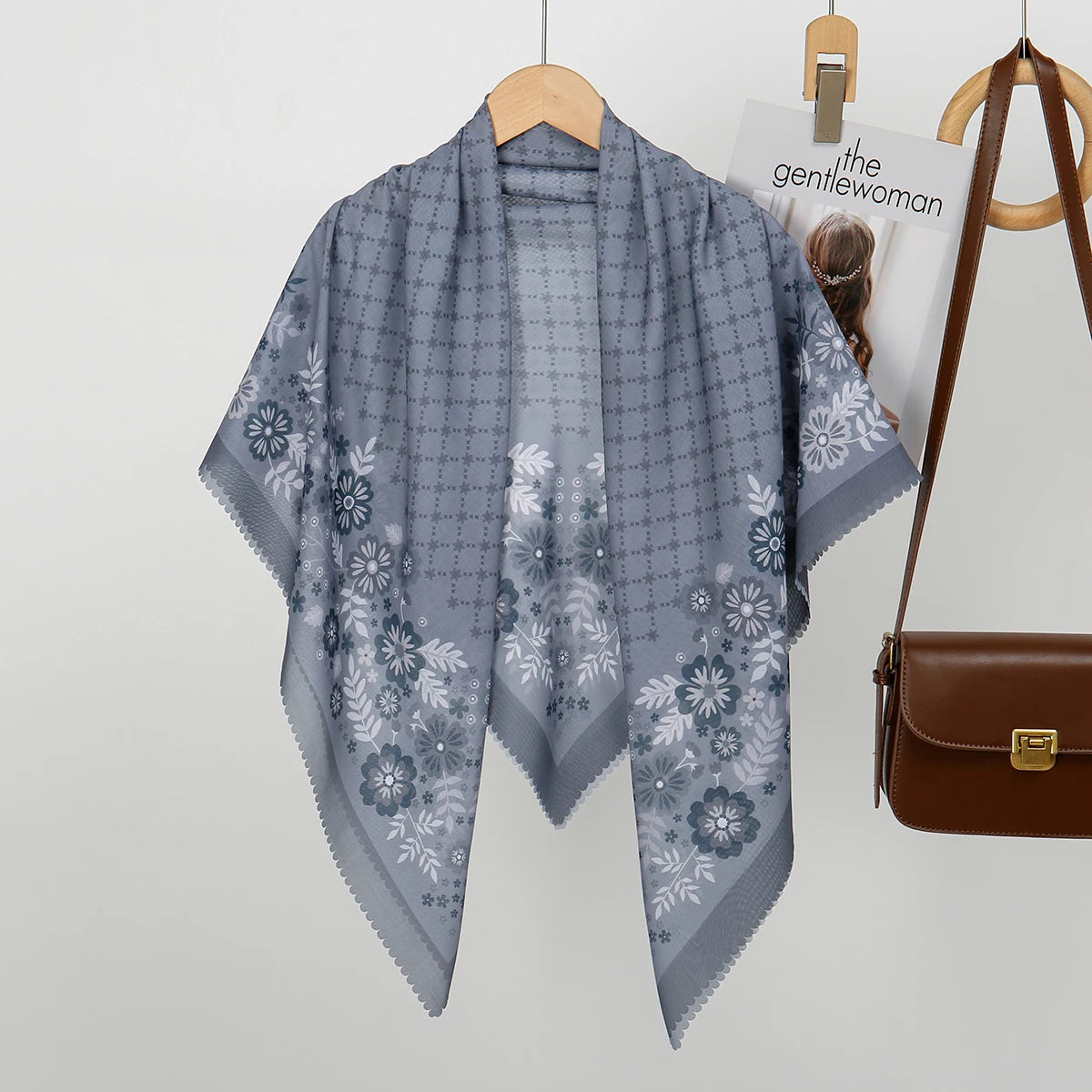 Helles blaues Blumen-Quadrat-Hijab-Schal auf einem Holzbügel.